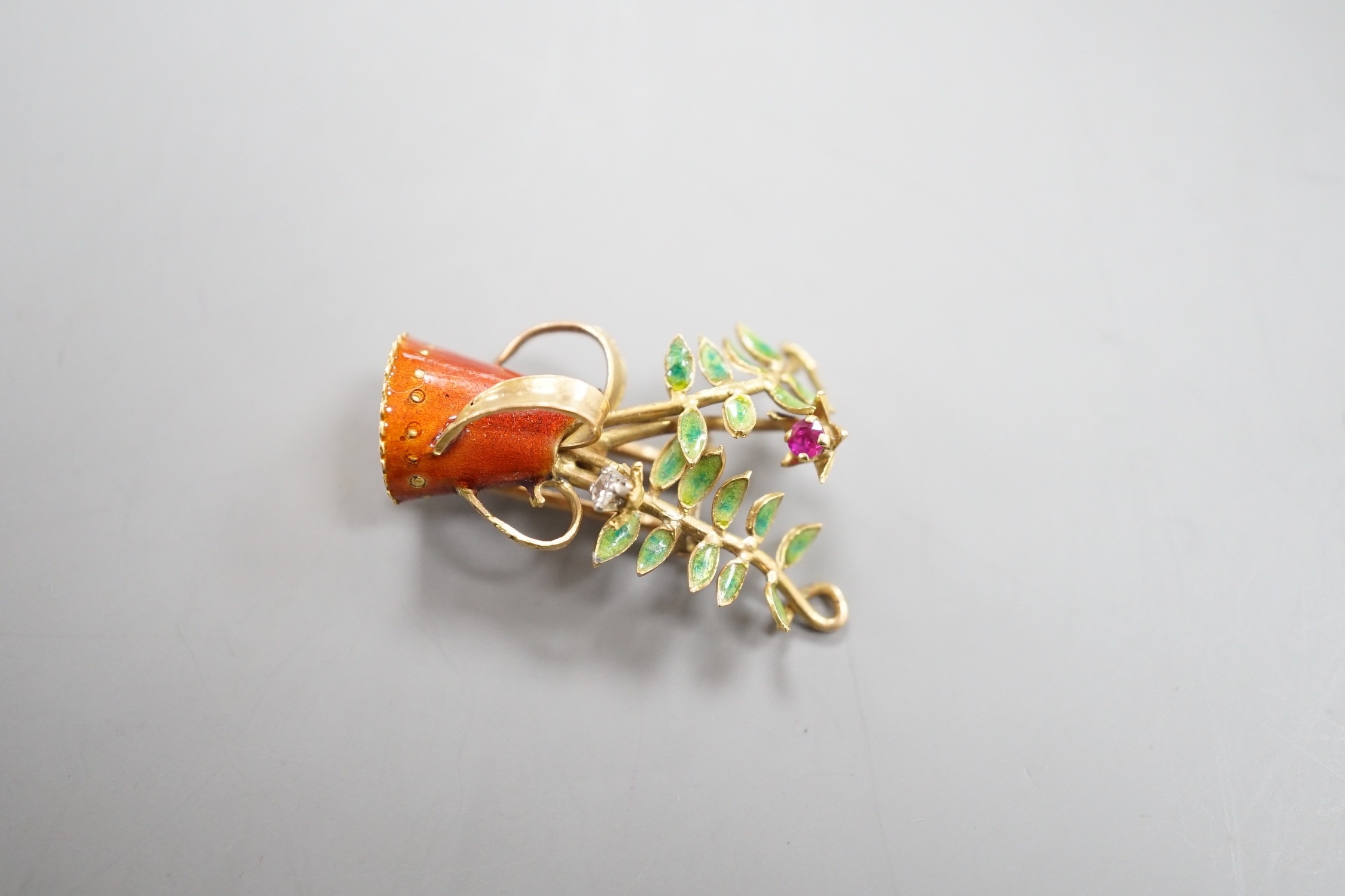 A French yellow metal (18ct poincon mark), two colour enamel, ruby and diamond set novelty brooch, modelled as a tyg with foliate stems, signed Marcel Pac, Paris, 29mm, gross weight 5.8 grams.